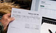 Faktura VAT RR za pszenicę trzymana przez rolnika na tle ekranu KSeF