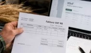 Faktura VAT RR za pszenicę trzymana przez rolnika na tle ekranu KSeF