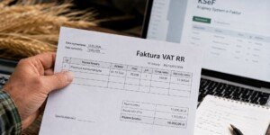 Faktura VAT RR za pszenicę trzymana przez rolnika na tle ekranu KSeF