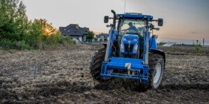 Ciągnik rolniczy podczas pracy w polu. Premie dla młodych rolników 2026.